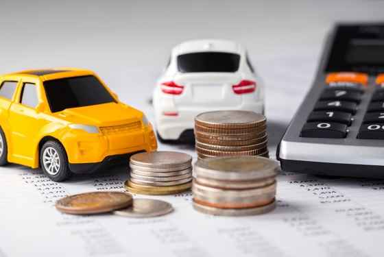 Cars and coins with calculator on financial statement